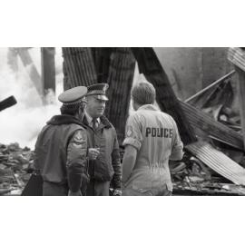 Police officers inspecting the aftermath of the Reid's (Cribb & Foote) fire, Bell Street, Ipswich, August 1985