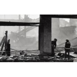 Firefighters walking though the remains of the Reid's store following the fire, Ipswich, August 1985