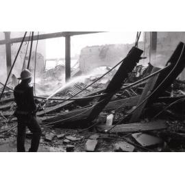 Firefighters walking though the remains of the Reid's store following the fire, Ipswich, August 1985