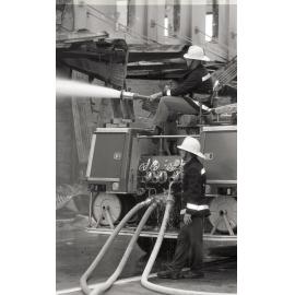 Firefighters hosing down the remains of the Reid's store following the fire, Ipswich, August 1985