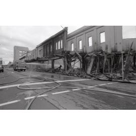 Firefighters hosing down the remains of the Reid's store following the fire, Ipswich, August 1985