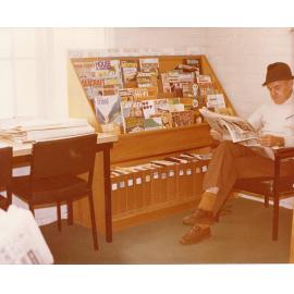 Library customer Mr Sneyd, reading the paper next to the magazine stand, Ipswich Municipal Library, corner of Nicholas and Limestone Streets, Ipswich, 1970s