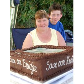 Deanna and Jared McDonald (aged 8) at the Heiner Road bridge with the caked baked by Deanna, Ipswich, September 2004 