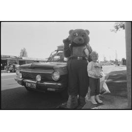 Unidentified child with the L.J. Hooker real-estate bear mascot and car entered in the Variety Bash, location unknown, 4th August 1994