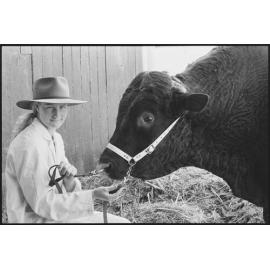 Unidentified young woman with cow at the Ekka, Brisbane Showgrounds, Brisbane, 20th August 1994