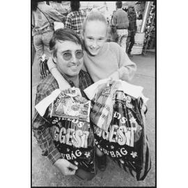 Unidentified man and girl with showbags at the Ekka, Brisbane Showgrounds, Brisbane, 21st August 1994