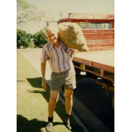Don Risson carrying the last bag of spuds when the business was sold, 1986