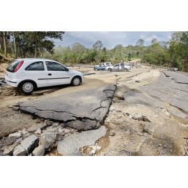 Members of the public riding through the road damage at the Kholo bridge which is currently closed after flood damage, Ipswich, 3rd January 2011