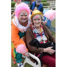 Leigh Wilkins dressed as a clown, with resident Maureen Cassidy and a lamb from the animal nursery that was part of the show-themed day at St Mary's Hostel, Ipswich, 16 May 2013