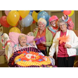 Residents Chelmer 'Chum' Voight, Dorothy Harris and Barbara Kopelke with employee Michelle Hammill, dressed as a clown, at the show-themed day at St Mary's Hostel, Ipswich, 16 May 2013