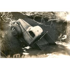 Truck, owned by W.A. Hughes Pty. Ltd.  in a hole at Rhondda Coalmine, Blackstone, Ipswich, c.1940s