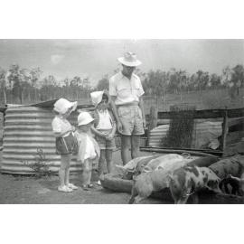 Members of the Foote family at Rockdale Farm, looking at their pigs, Peak Crossing, Ipswich, early 1930s