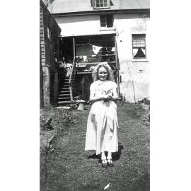 Young girl in backyard of home on Brisbane Street, West Ipswich, 1948