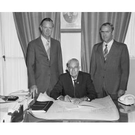 The Mayor J T Finimore and two unidentified men signing the contract thought to be for the redevelopment of the Ipswich City Council Humanities building, South Street, Ipswich, c.1970